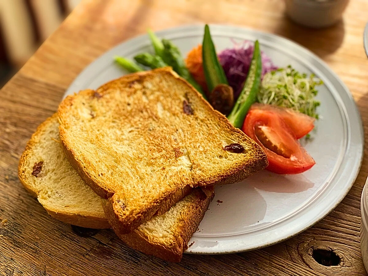 こんがり焼いたぶどうパンと彩りサラダ。