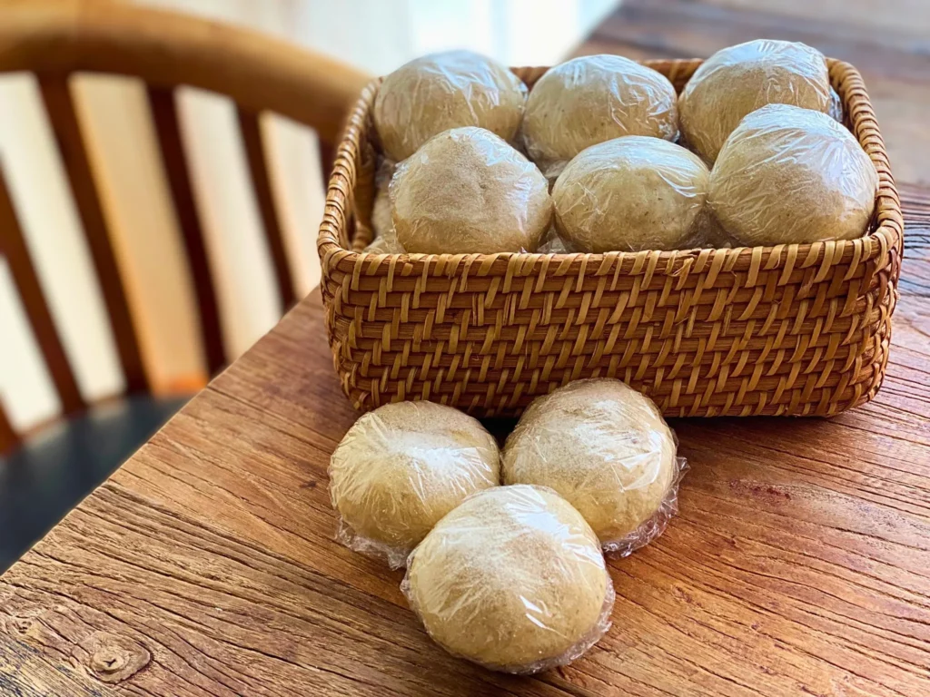 焼き上がった丸パンを1つずつラップでくるんで冷凍する準備