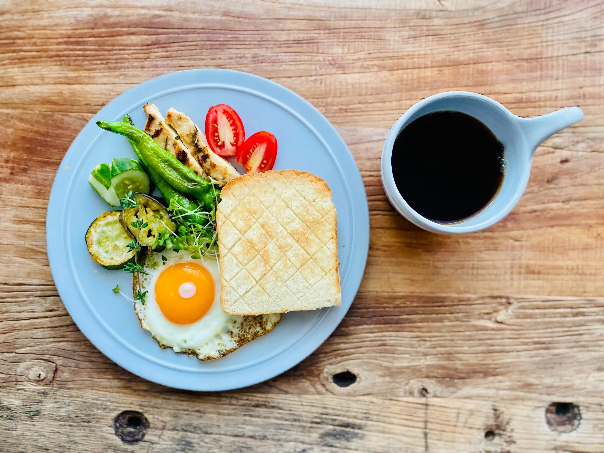 平日の朝ごはんプレート。ブレッドオーブンで焼いたトーストに目玉焼き、ロースト野菜、グリルチキン、そして自家焙煎のコーヒー