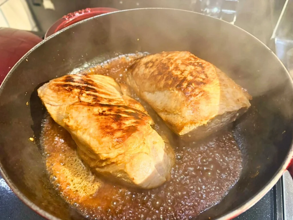 鍋の中で豚肉の表面をこんがり焼き付けている様子