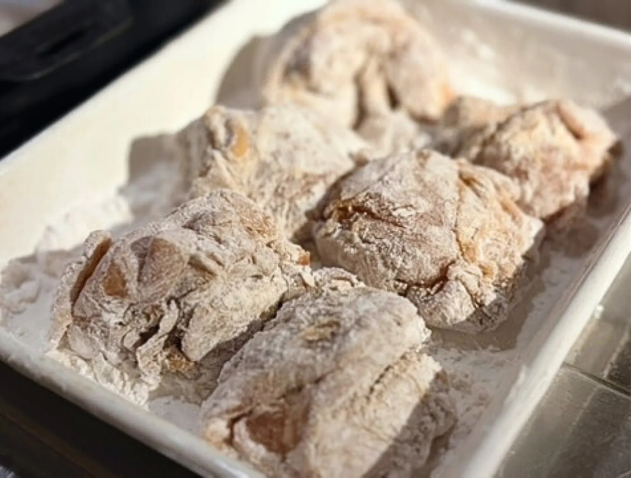 下味をつけた鶏もも肉に片栗粉をまぶしている様子