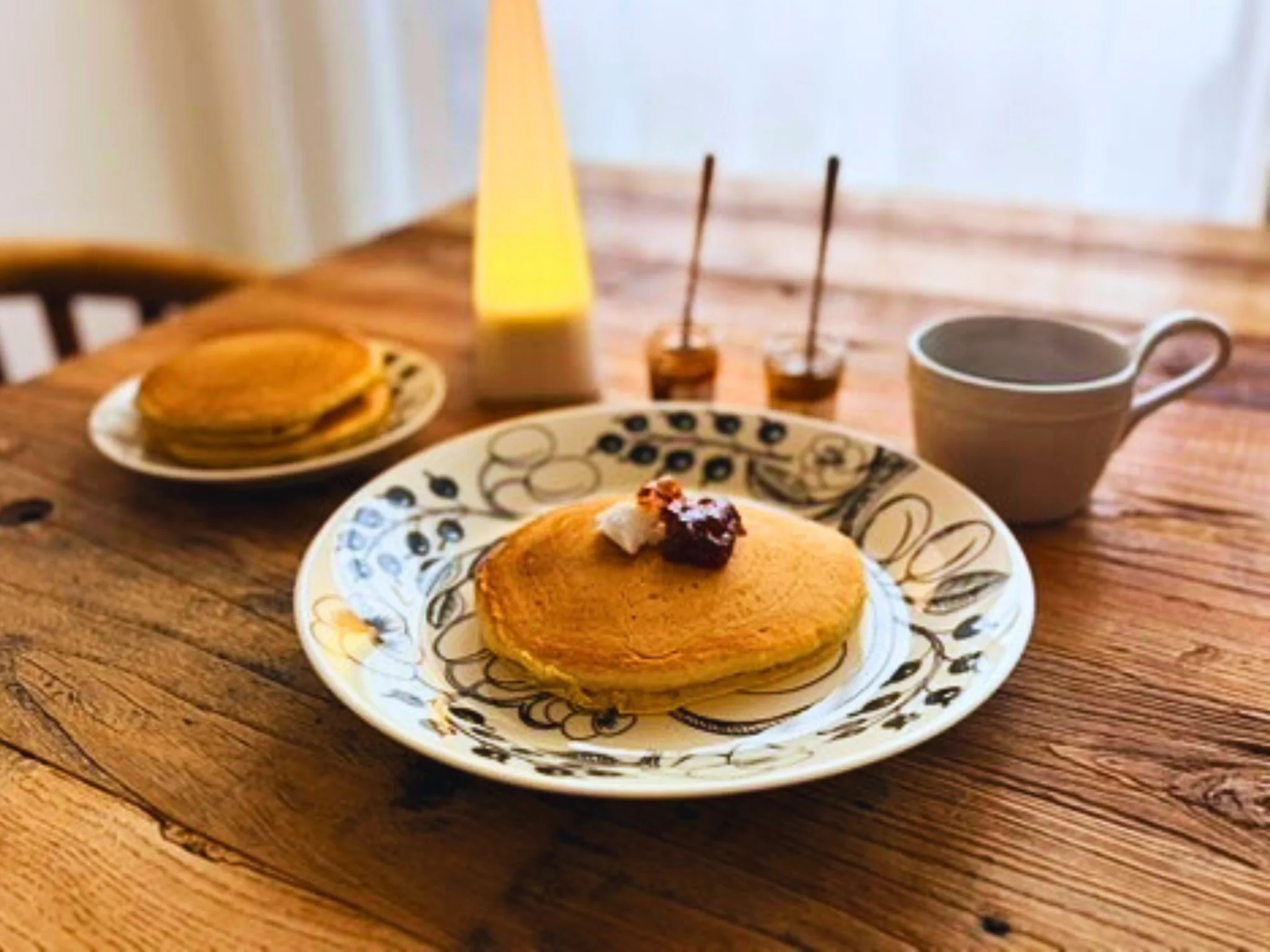 ココナッツミルクで焼いたホットケーキとコーヒーの朝ごはんの食卓