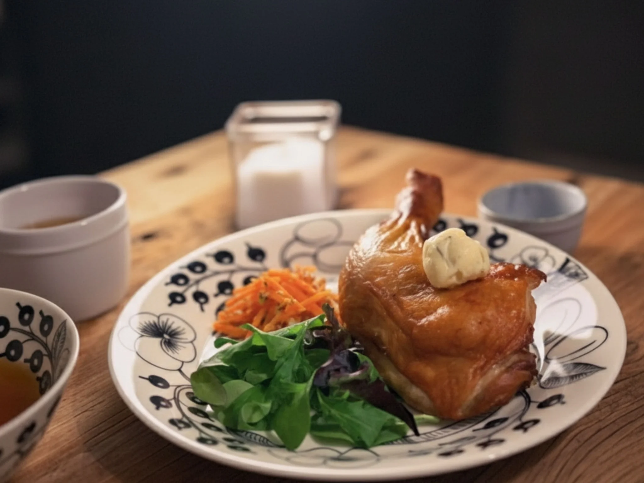 ハーブバターをのせたローストチキンのある静かな食卓