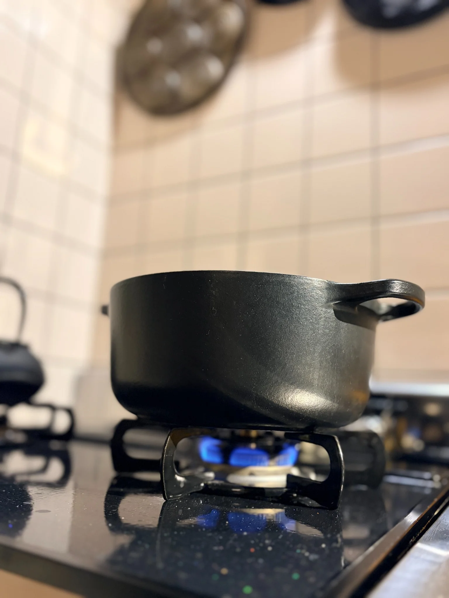 コンロの上で火にかけた黒い鍋。静かに温まっていく朝の台所