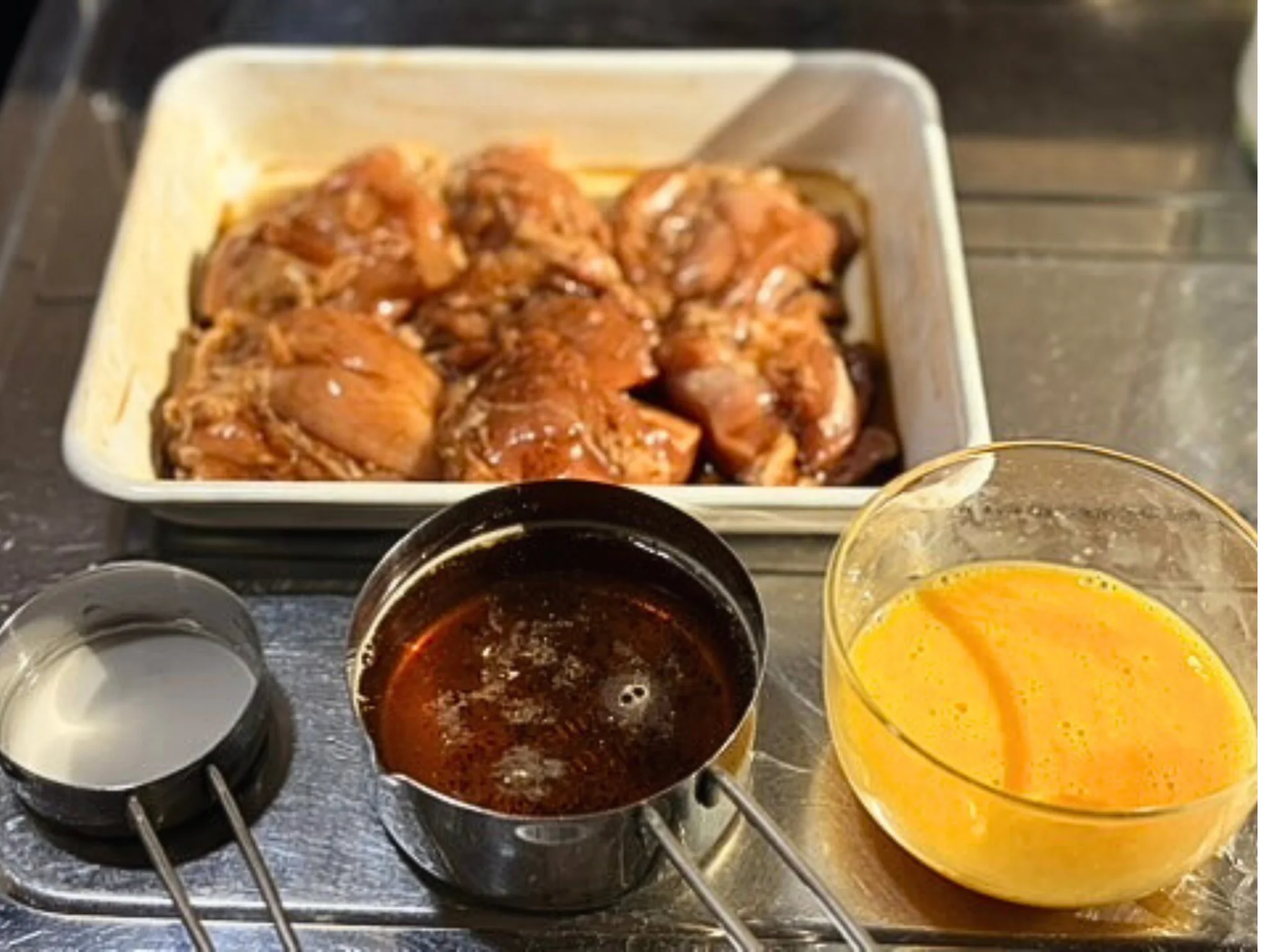 鶏もも肉ににんにく醤油とみりんで下味をつけている様子