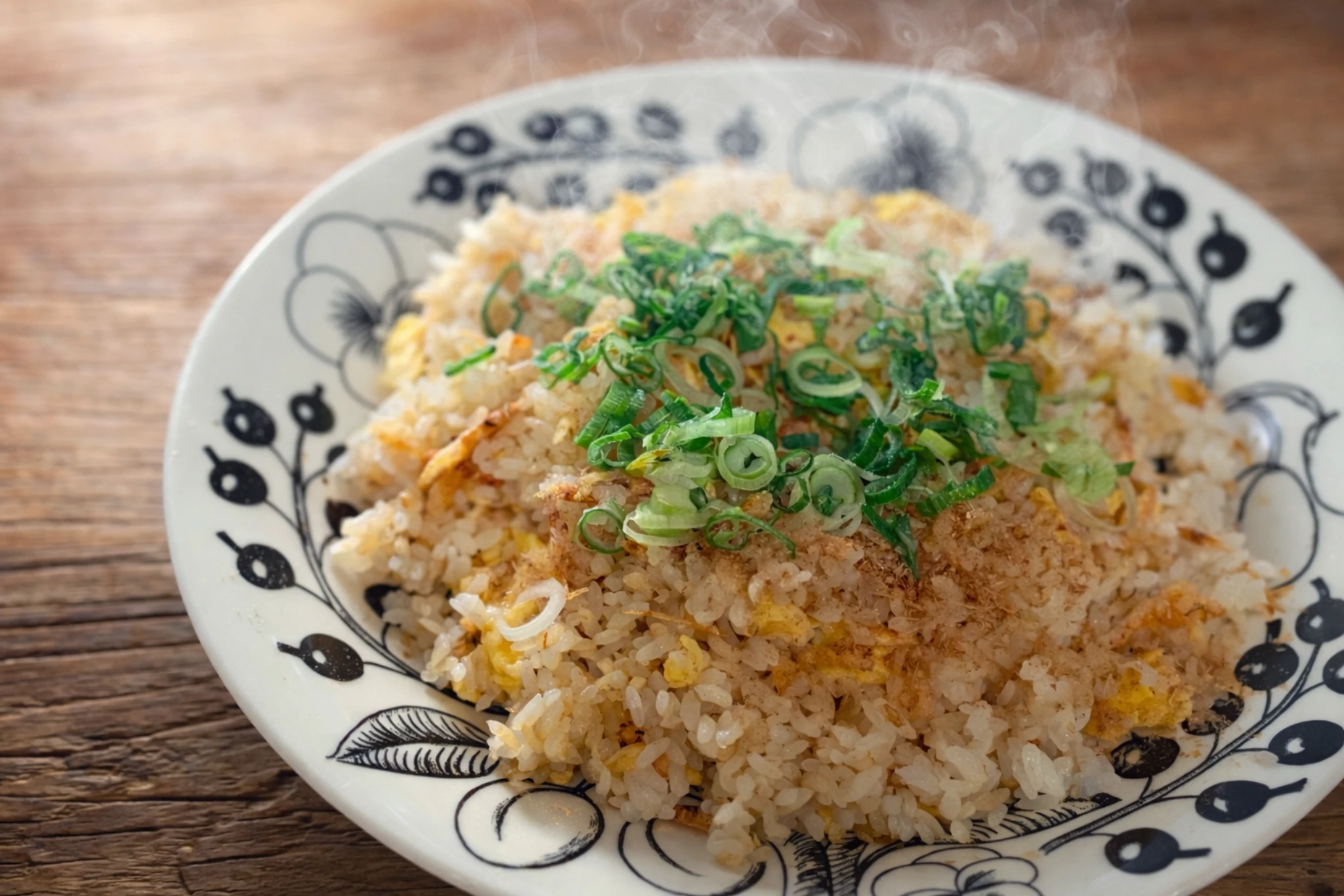 器に盛った卵チャーハンに刻みねぎをのせ、かつお節がふわりとかかった家庭的で温かみのある一皿
