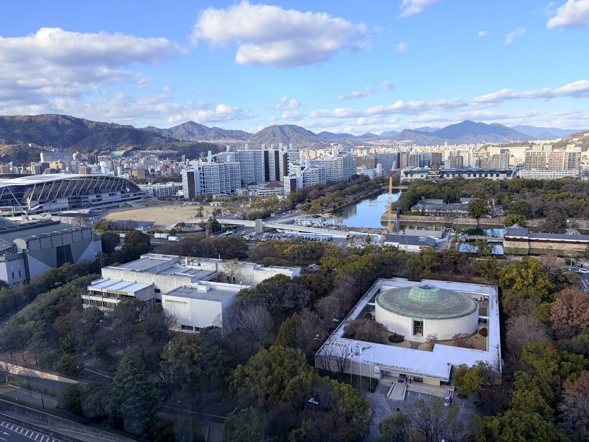 ホテルの部屋から見える広島の街並みと川。静かな午後の光に包まれた景色