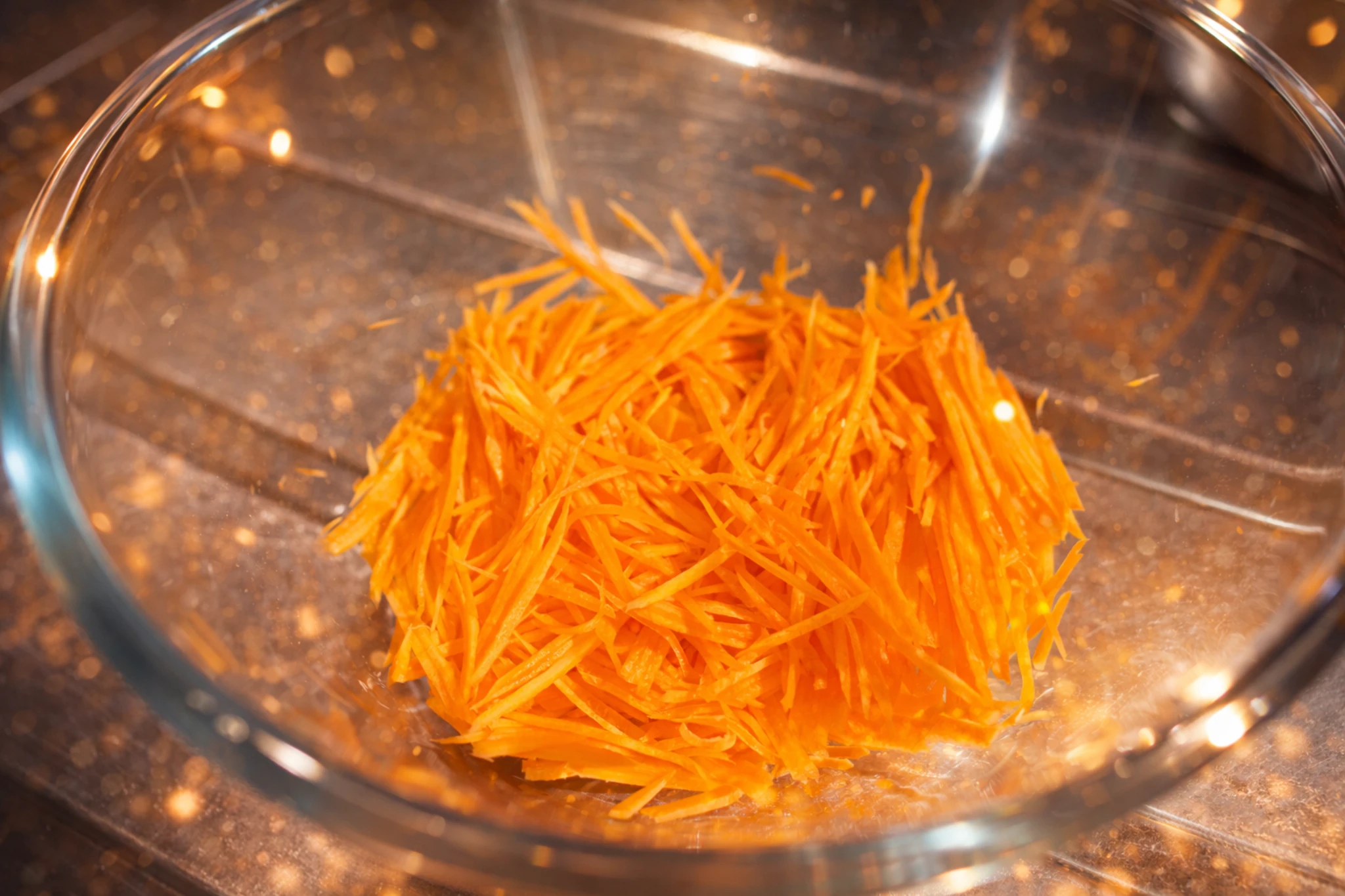 レンジで作ったにんじんのごまあえ。細切りにんじんをガラスボウルに入れたシンプルな一品