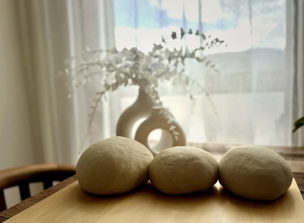 Betty Crocker Traditional White Breadの生地。窓辺の自然光の中で3つのパン生地が並んでいる。