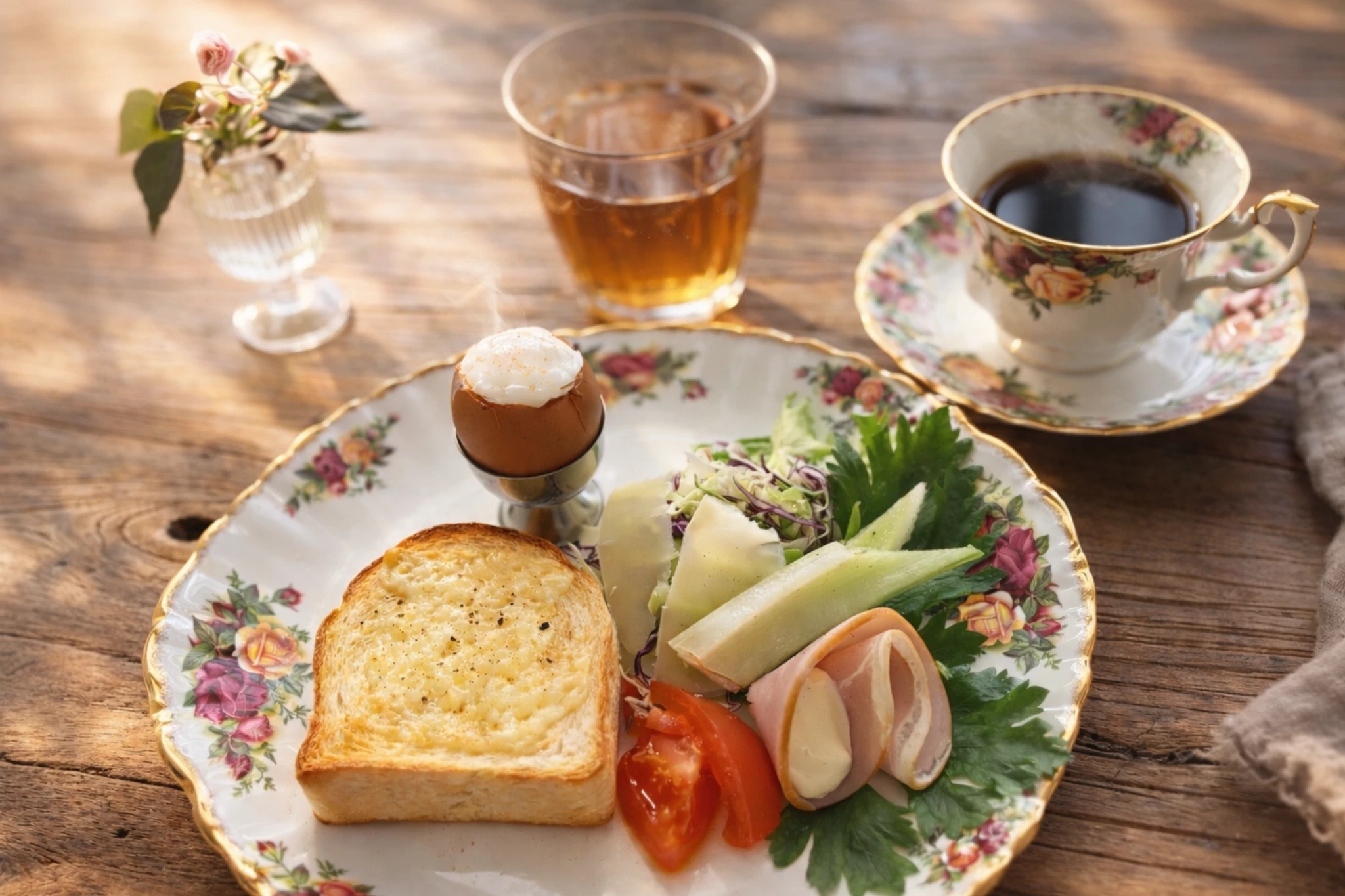 花柄の皿にトーストと半熟卵、サラダ。珈琲と小豆茶を添えた静かな朝食の風景